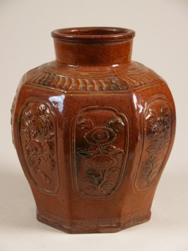 Pot, achthoekig, met decor in reliëf van vakken waarin bloemen en voorzien van bruin glazuur